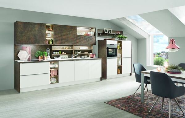 Moderne Einbauküche mit weißen Fronten, Essbereich und viel Tageslicht im Dachgeschoss.