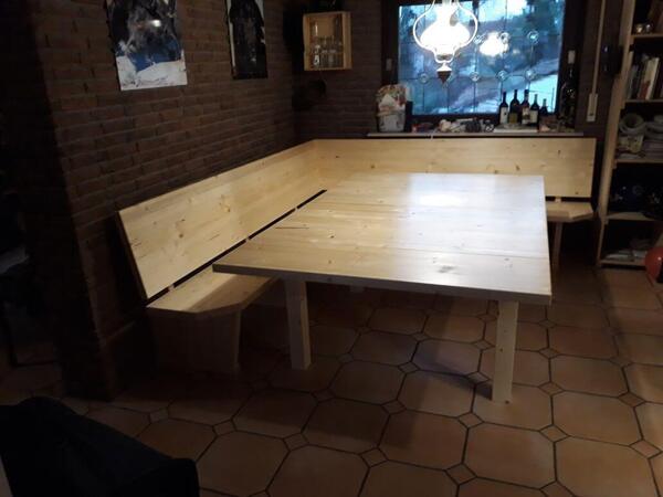 Eckbank aus hellem Holz mit passendem Esstisch in gemütlicher Wohnküche.